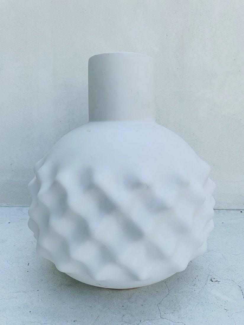 A modern gourd shaped white tone ceramic Vase: A modern gourd shaped white tone ceramic audio foam detailed vase. Measurements: 12 inches high x 10.50 inches in diameter x 3.25 inches spout diameter. All items are sold as is. The auction house doe