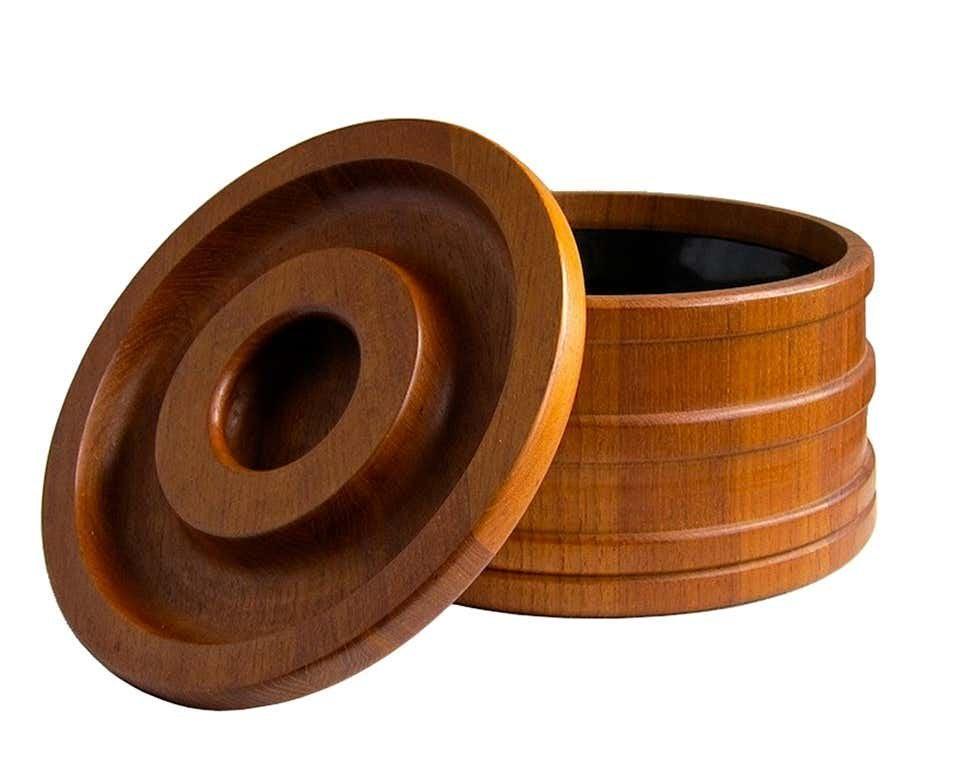 Dansk Staved Teak Banded Ice Bucket by Jens Quistgaard: This staved teak lidded ice bucket was designed by Jens Quistgaard for Dansk. The container is a slightly tapered cylinder banded with rings and the lid has an integral handle. Retains its original bl
