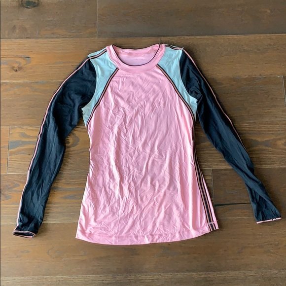 Women’s long sleeve Shirt by Lululemon size 4: Beautiful long sleeve shirt designed and manufactured by Lululemon in size 4, like new condition. The sleeve feature thumb holes and there is a back pouch with a zipper closure. The color is like salm