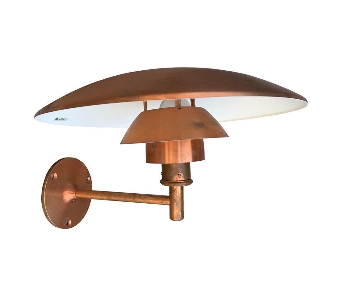 PH Copper Sconce by Poul Henningsen for Louis Poulsen: The piece comes in the original box, never installed.Developing a patina. Measurements: 19 deep x 11 high x 18 shade diameter. All items are sold as is. The auction house does not warrant authenticity