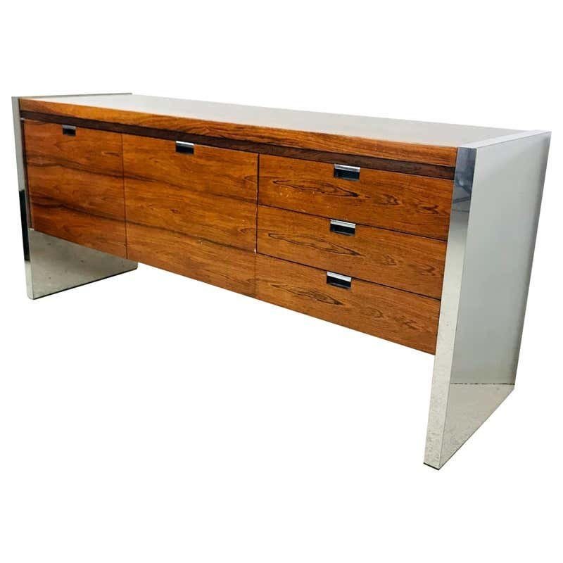 Rosewood & Stainless Credenza by Roger Sprunger/Dunbar: Roger Sprunger for Dunbar rosewood and stainless steel executive credenza dating from the early 1970s. The credenza has generous storage having 2 file cabinets and 3 center drawers.Measurements:61 inc