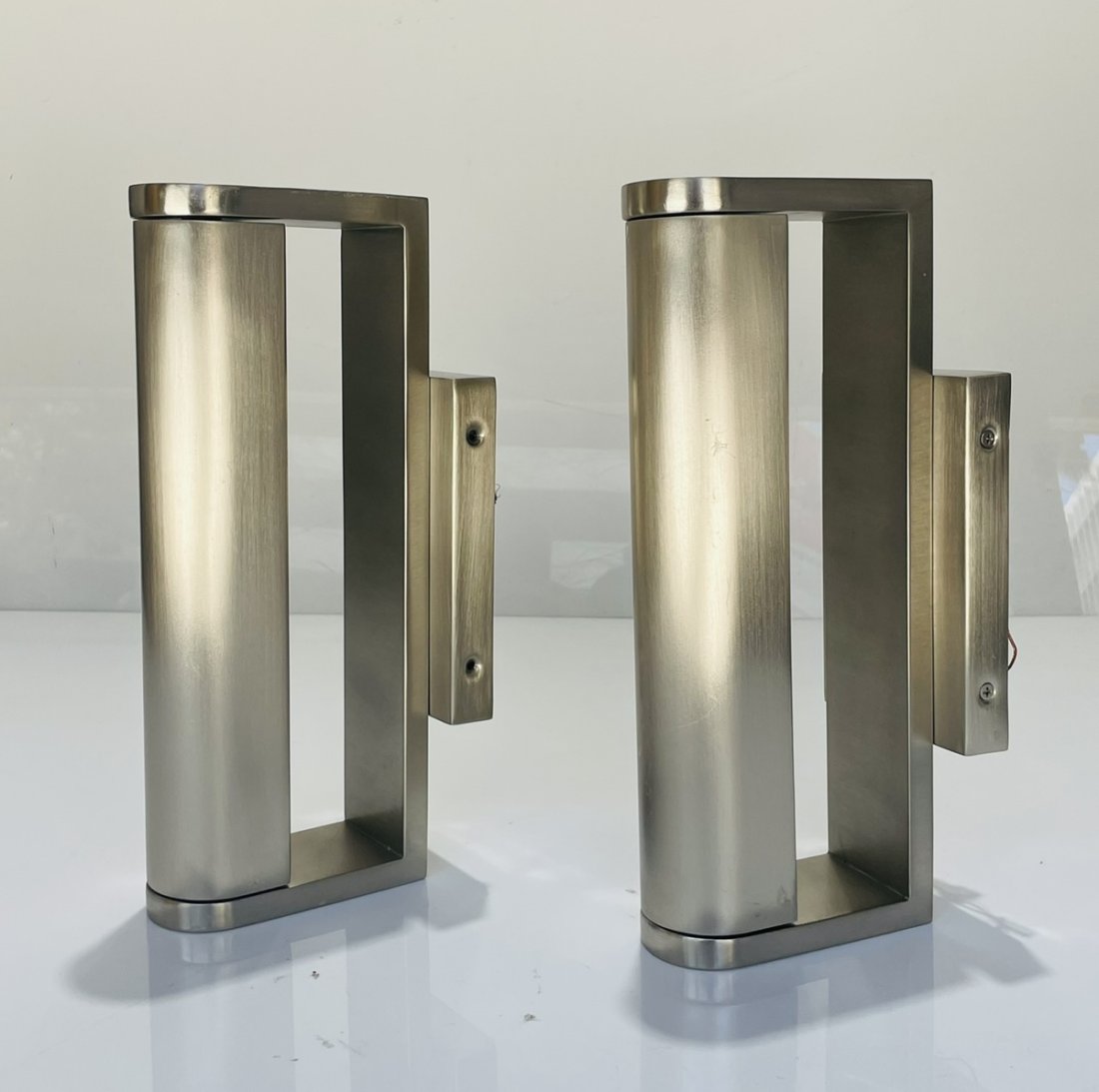 Pair of Wall sconces in Brushed Nickel: Measurements: 12 inches high x 2.25 inches wide c 5.50 inches deep/projection from wall. All items are sold as is. The auction house does not warrant authenticity on any specific piece. THERE ARE NO R