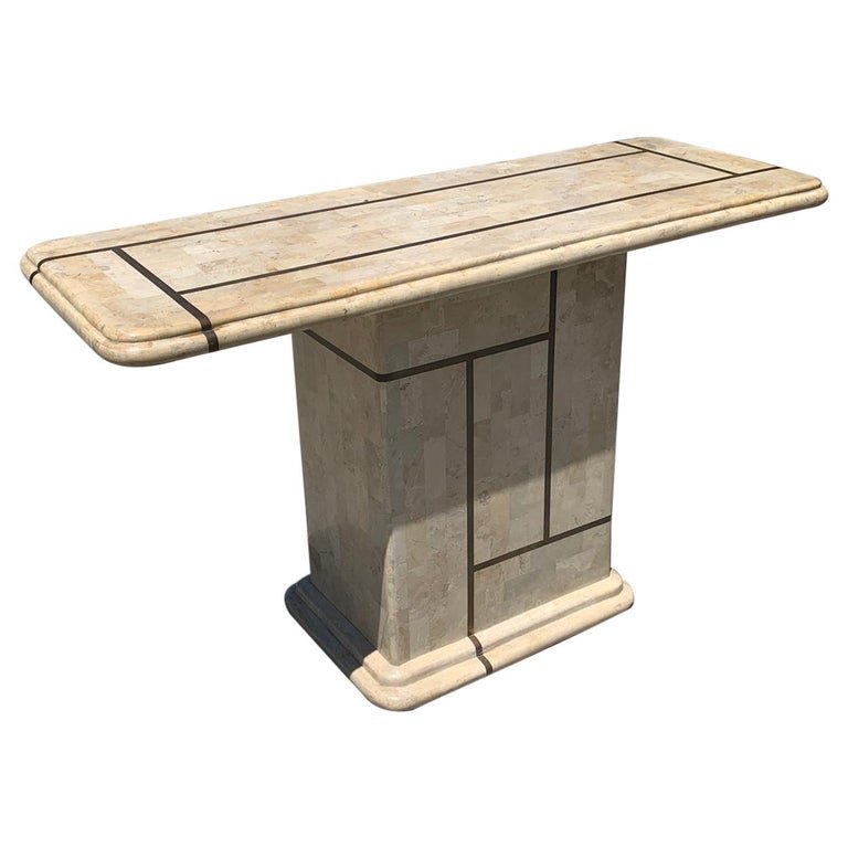 Tessellated Stone & Brass Console Table: Beautiful console table executed in tessellated stone and brass inlay. The piece has a beautiful geometric brass design on the base and top. The brass has a beautiful aged patina and the stone a rosy,