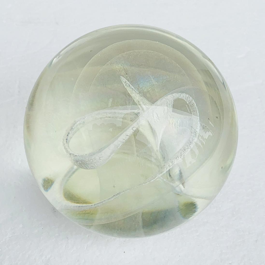 Signed Vintage Robert Stephan Art Glass Paperweight: A signed vintage art glass paperweight by American glass artist, Robert W. Stephan dating to 1983. This clear glass sphere was handcrafted with colorful internal iridescence and swirls, creating spark
