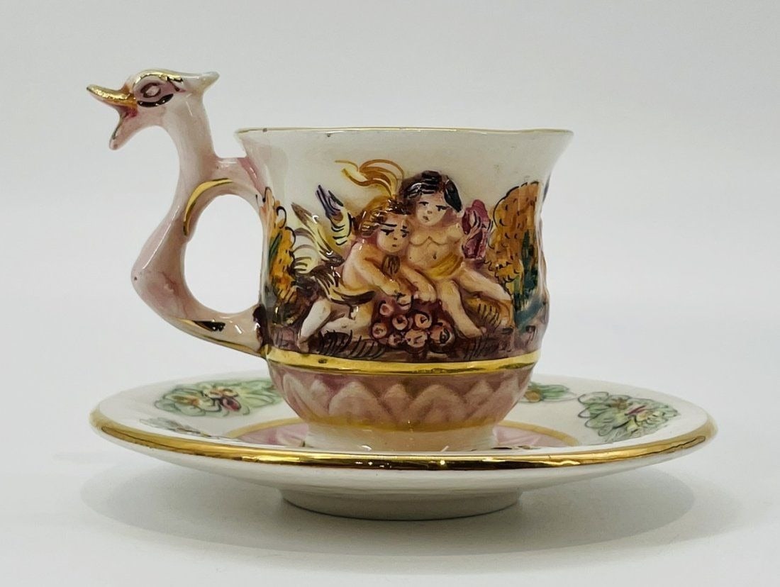 Capodimonte Cup & Saucer, Hand-Painted Relief Cherubs Gold Trim, Labeled.: Vintage Italian Capodiminte cup and saucer, hand painted and gold trim. Measurements: Cup: 3 inches high x 3.50 inches wide x 2.43 inches deep. Plate: 4.50 inches in diameter x .75 inches high. All it