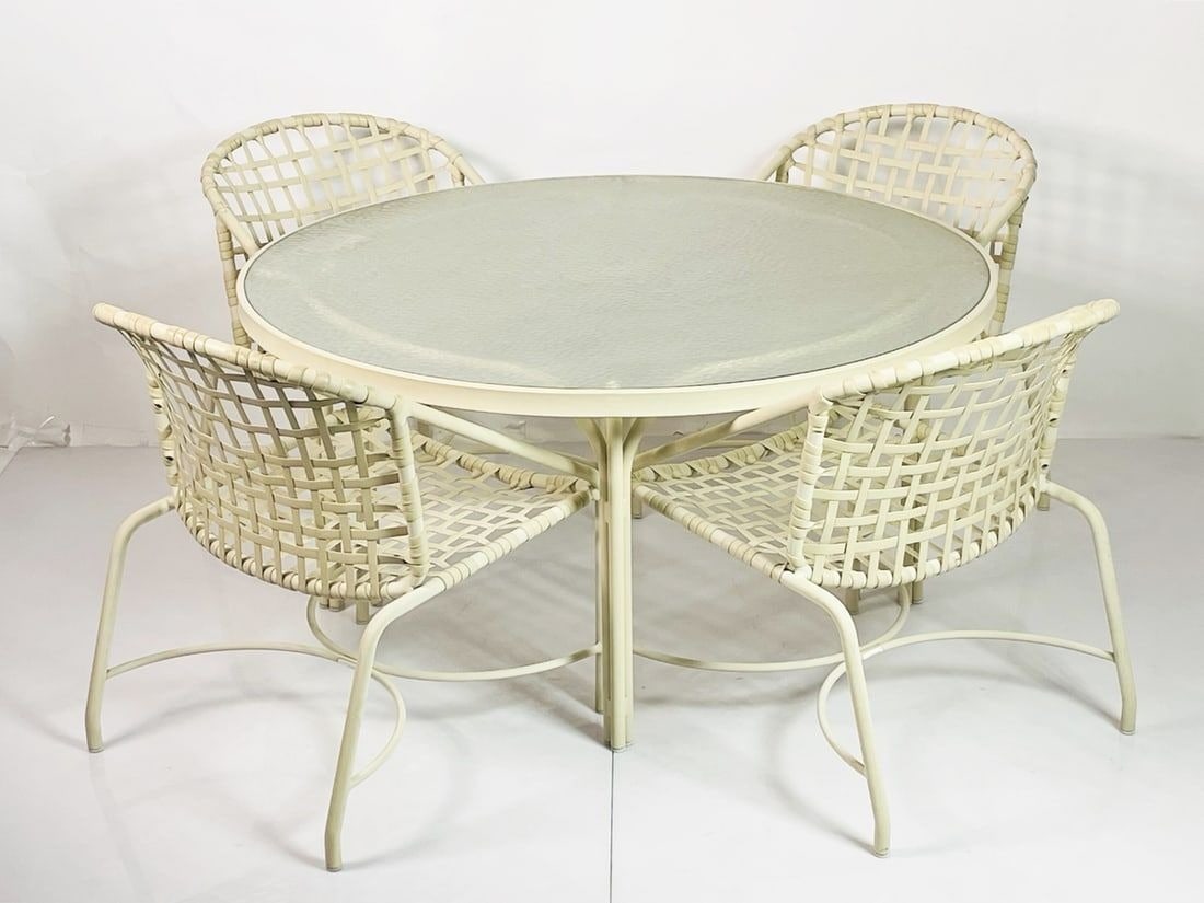 A Tadao Inouye for Brown Jordan "Kantan" patio set: A Tadao Inouye for Brown Jordan "Kantan" patio setMid-20th century. Designed 1956, comprising four chairs, each with a cream aluminum frame and vinyl strapping and a circular table with glass top, 6 p