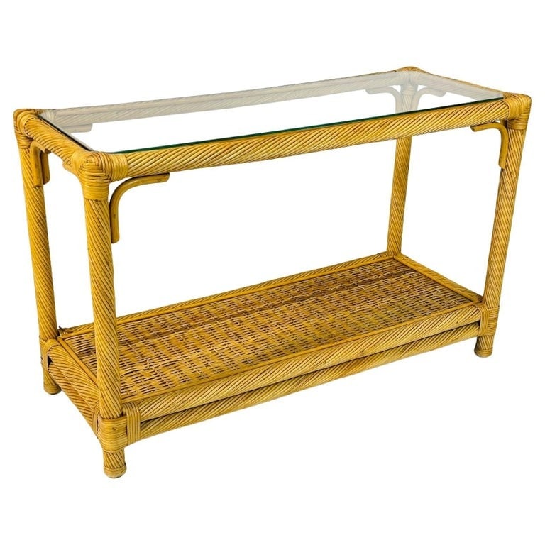 Vintage Twisted Rattan Console Table With Glass Top: Beautiful console table designed and manufactured in the United States in the 1960s.The table is made out of pencil thin rattan material with a glass top.Measurements: 44 inches wide x 17.50 inches de