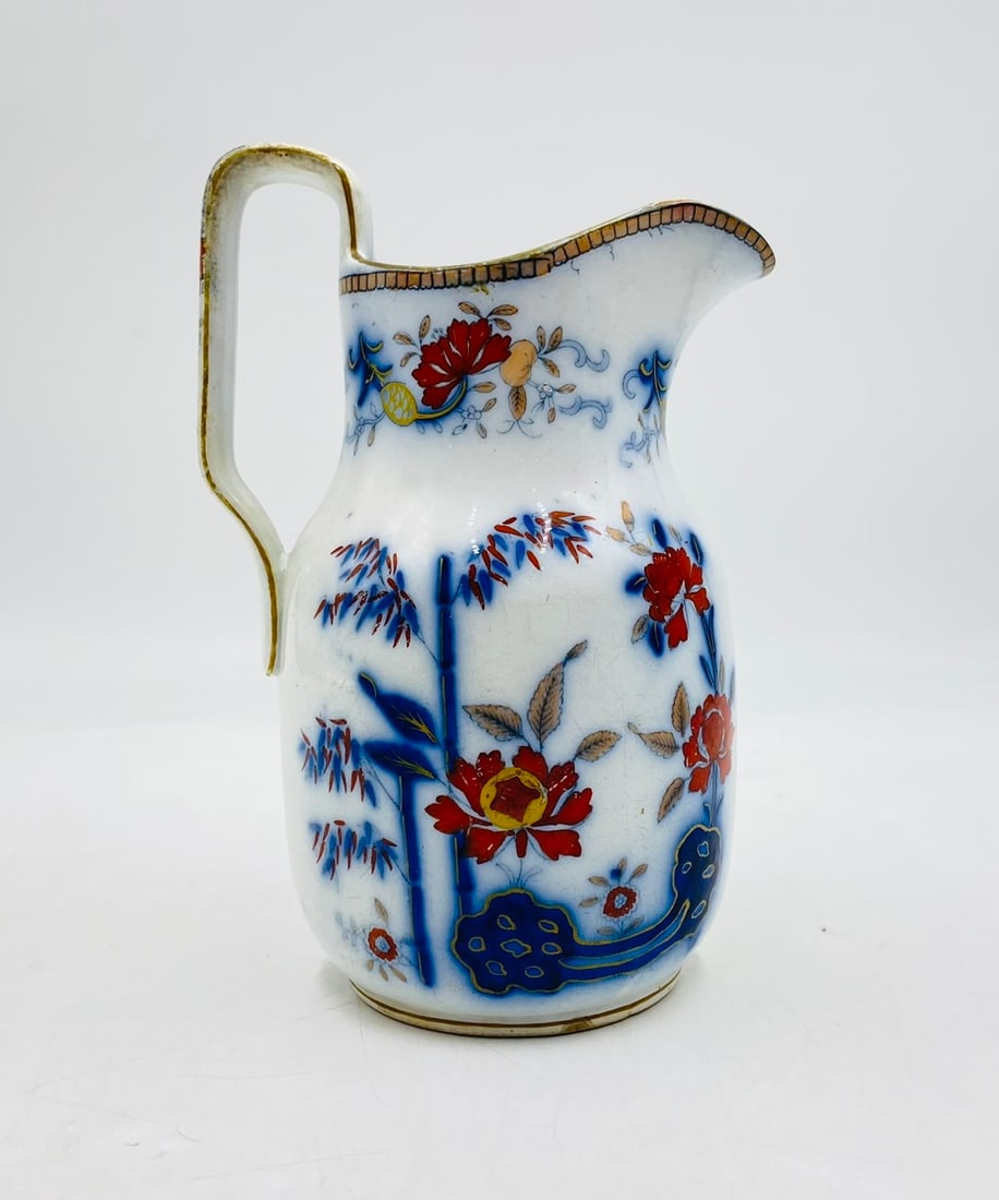 Antique Porcelain Cream Pitcher by Davenport: Antique cream pitcher designed and manufactured by Davenport. The piece has beautiful hand painted foliage and gold accents. The piece retains the Davenport hallmark and pattern number 1445. Measureme