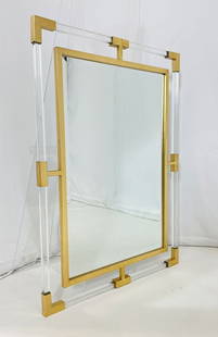 Lucite and Brass Tone Wall Mirror by Uttermost: Lucite and brass tone wall mirror by uttermost. Measurements: 37.25 inches high x 27.50 inches wide x 1 inch deep. All items are sold as is. The auction house does not warrant authenticity on any spec