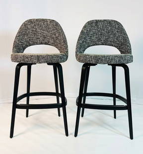 Pair of Eero Saarinen Barstools for Knoll, Labeled & Dated: Pair of barstools designed by Eero Saarinen and manufactured by Knoll. The stools are upholstered in a black light gray fabric, the stools have an ebonized wooden frame and a metal bar for the footres
