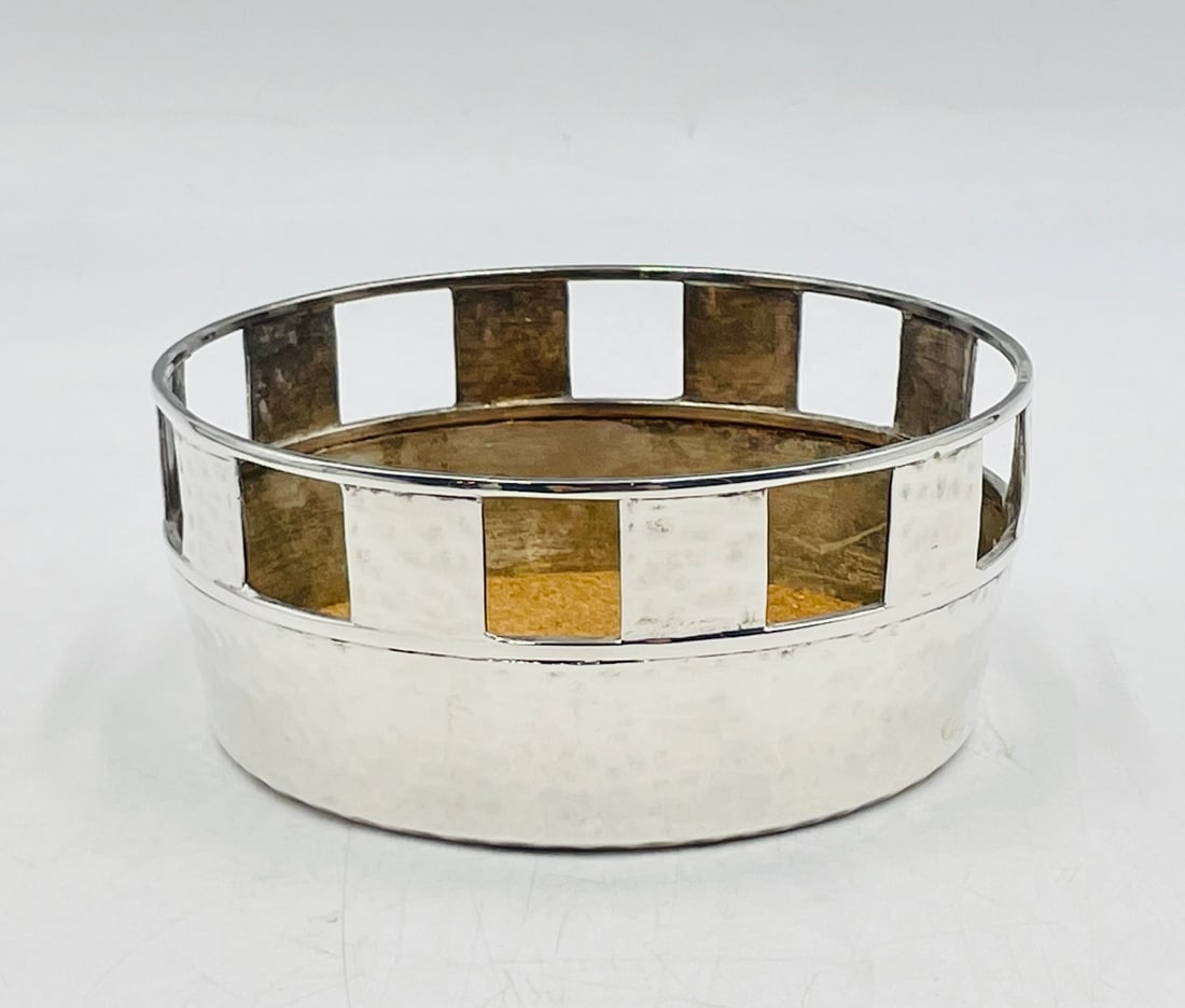 Bold Emilia Castillo Silver Wine Coaster with Architectural Pierced Rim: Elegant silver-plated bottle coaster by celebrated Mexican designer Emilia Castillo, marked “Emilia Castillo / TO-85 / Mexico M.R. / Plateado.” Crafted in silver-plated brass with a hammered s