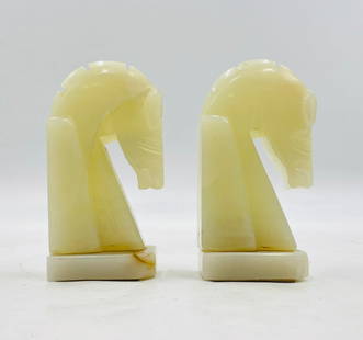 Pair of Vintage Hand-Carved Onyx Horse Head Bookends in the Style of Chess Knights: A charming pair of vintage bookends finely hand-carved from creamy pale onyx, each shaped in the form of a stylized chess knight. These sculptural pieces feature soft translucence with natural