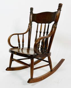 Early 1900's Child Rocking Chair: Early 1900s child's rocking chair made in solid wood, with bent arms and beautiful carved details. Measurements: 26 inches high x 15.50 inches wide x 22.50 inches deep x 10.50 inches seat height. All