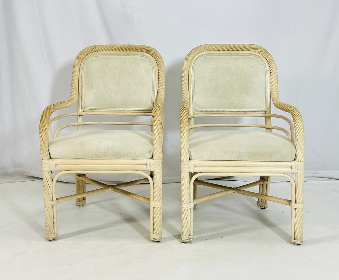 Pair of Vintage Rattan Lounge Armchairs with Cream Upholstery, Coastal Modern Style: Charming pair of vintage rattan armchairs featuring sculptural frames with twisted reed detailing and double-arm rail design. These chairs exude relaxed coastal elegance and are upholstered in a soft,