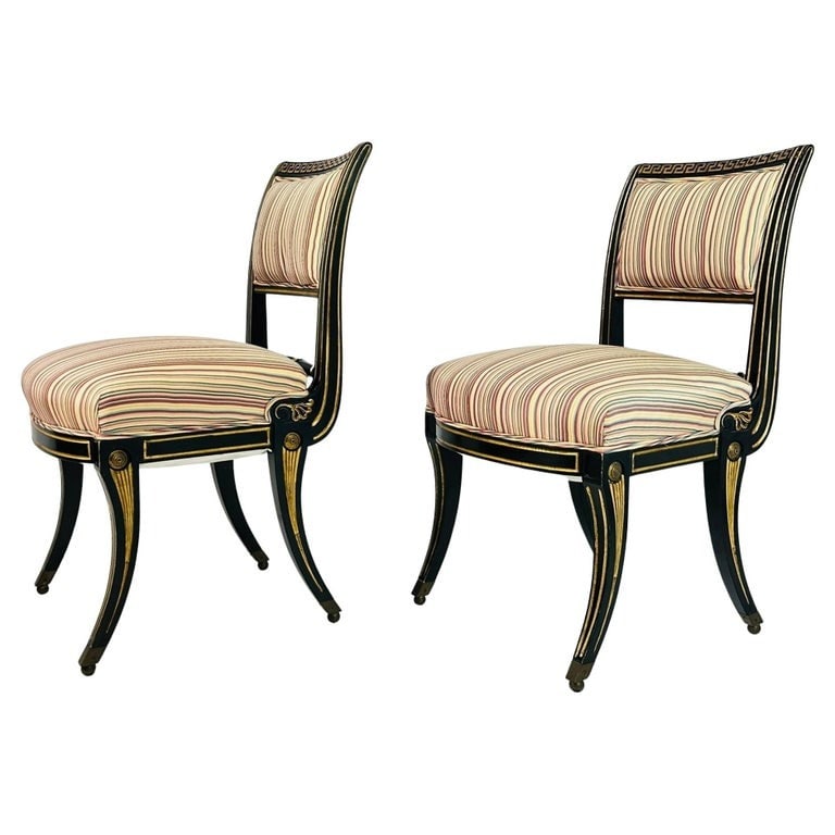 Italian Neoclassical Ebonized and Parcel Gilt Slipper Chairs: Pair of antique slipper chairs with ebonized and parcel gilt wooden frames and upholstered in a silk fabric. The chairs have beautiful silhouettes, they have sold brass caps on the legs, a Greek desi