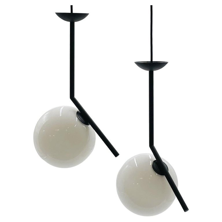 Pair of IC S Pendant Lights by Michael Anastassiades for Flos: The IC S Pendant Light from FLOS is a case study in balance.After watching a video clip of a contact juggler, designer Michael Anastassiades was inspired by the skill it took to spin and move the set