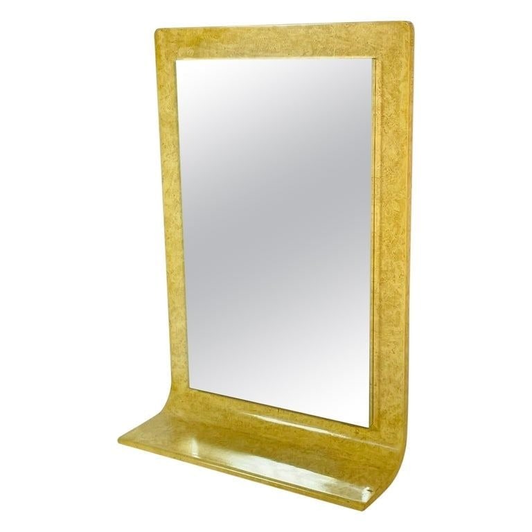 Large Wall Mirror in the style of Karl Springer: Stunning wall mirror with a built in shelf in the style of Karl Springer.Lacquered finish.Measurements:49 inches high x 33 inches wide x 12 inches deep.All items are sold as is. The auction house does