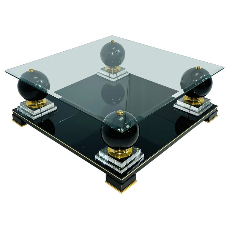 French Coffee Table With Bronze Accents in the Style of Roche Bobois: Stunning coffee table designed and manufactured in France in the 1980s. The table is made out of wood, glass and bronze. The table has 4 large wooden spheres supporting the glass top that is secured