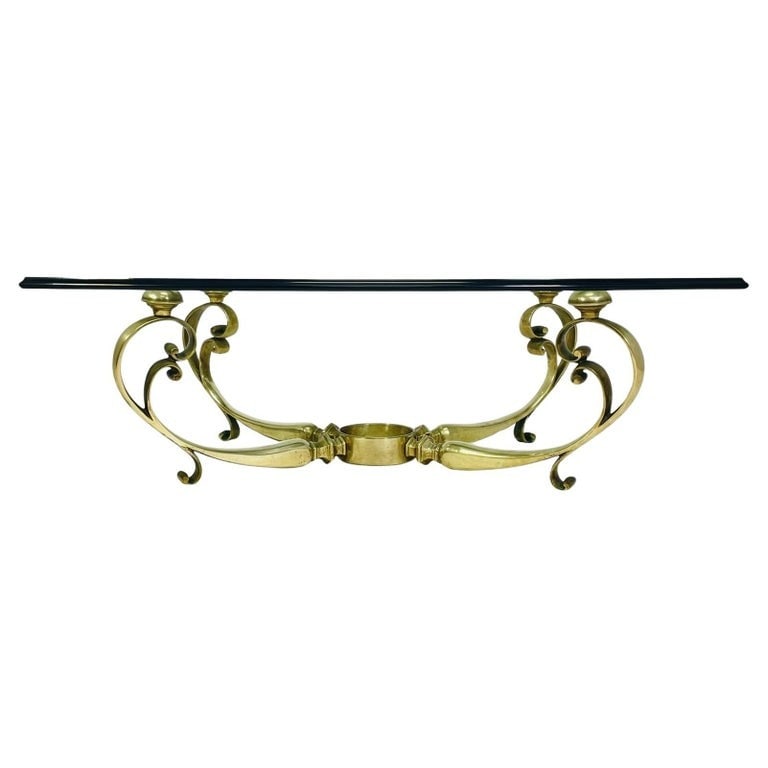 French Coffee Table With Brass base and Glass Top, Circa 1940s.: French coffee table having a brass base and glass top.Circa 1940s.Unmarked.Measurements: 49 inches wide x 35.50 inches deep x 15 inches high.All items are sold as is. The auction house does not warran