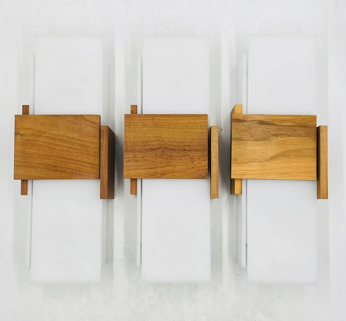 Set of 3 Vintage Style Wall Sconces in Lucite & Walnut Wood by Cerno: Set of three vintage style wall sconces in white Lucite and walnut wood accents. The pieces are manufactured by Cerno and part of the Acuo collection. The pieces retain the manufacturers label. Mea