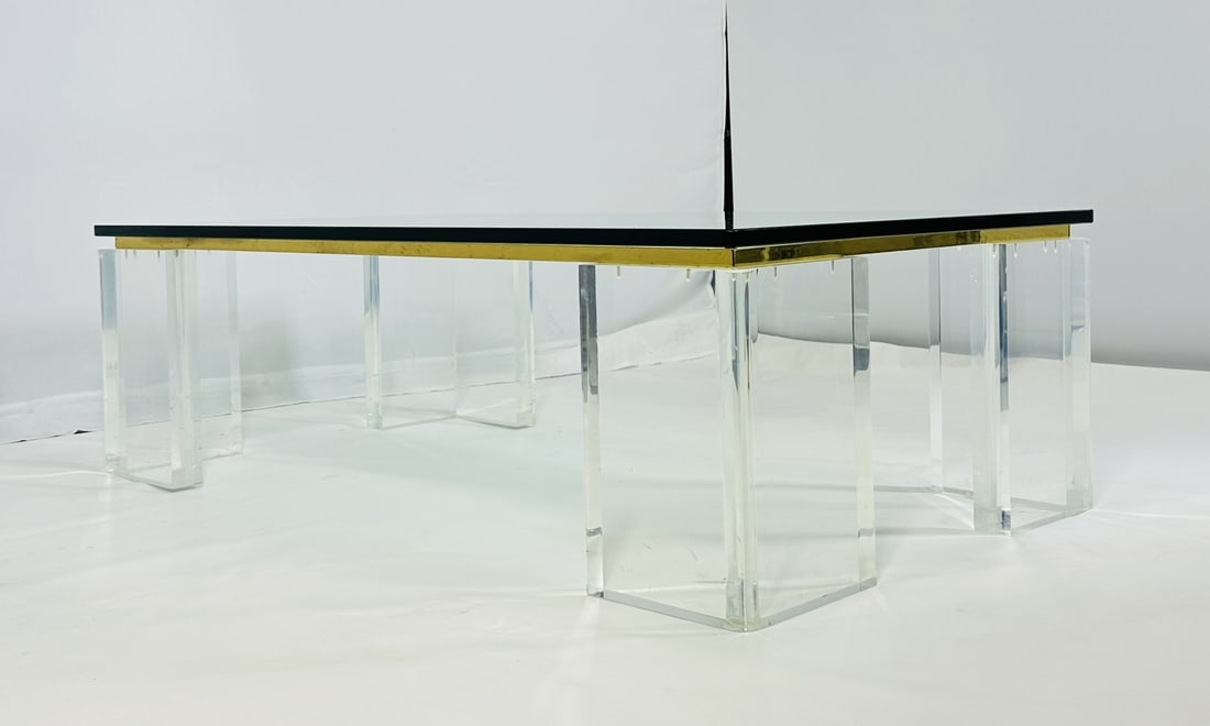Stunning Lucite, Brass & Glass Coffee Table After Karl Springer: Stunning coffee table designed and manufactured in the United States in the 1970s. The table has Lucite legs that are 2 inches thick, they are attached to a brass frame and topped with a thick glass t