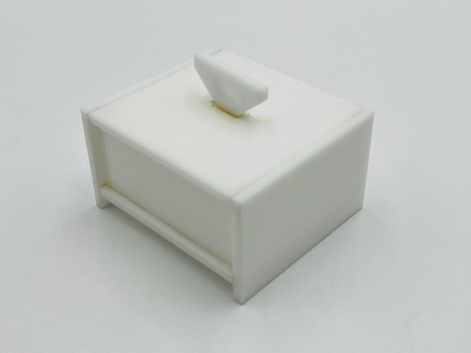 Vintage Jewelry Box in White Lucite in the style of Charles Hollis Jones: Vintage jewelry box in white Lucite styled after Charles Hollis Jones.Measurements:4 inches wide x 3.50 inches deep x 3 inches high including handle.All items are sold as is. The auction house does no