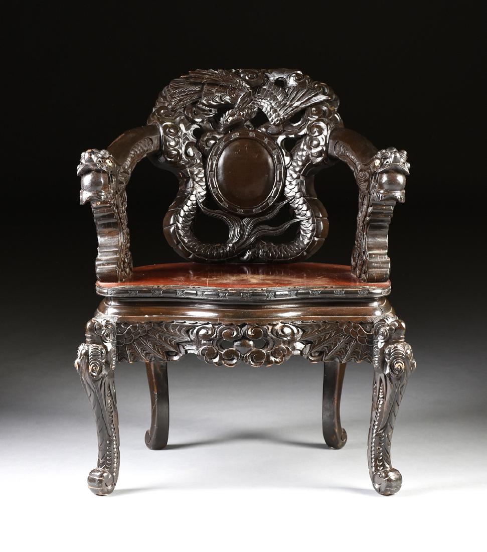 A CHINESE EXPORT EBONIZED WOOD FIGURAL DRAGON ARMCHAIR,: A CHINESE EXPORT EBONIZED WOOD FIGURAL DRAGON ARMCHAIR, EARLY 20TH CENTURY, POSSIBLY REPUBLIC PERIOD (1912-1949), the shield form back with a mother-of-pearl inlaid eye phoenix carved crest within pie