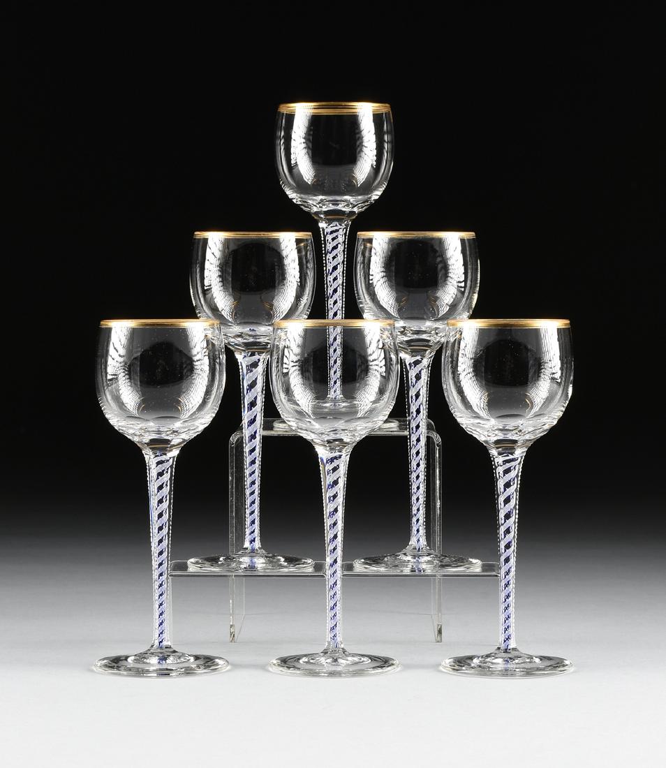 A SET OF SIX BOHEMIAN CUT GLASS WINE GLASSES WITH CASED: A SET OF SIX BOHEMIAN CUT GLASS WINE GLASSES WITH CASED CANE STEMS, MID 20TH CENTURY, the tall wine glasses with slice cut bowl on tapered notched stem with blue and white twisted cane, gilt rim. Heig