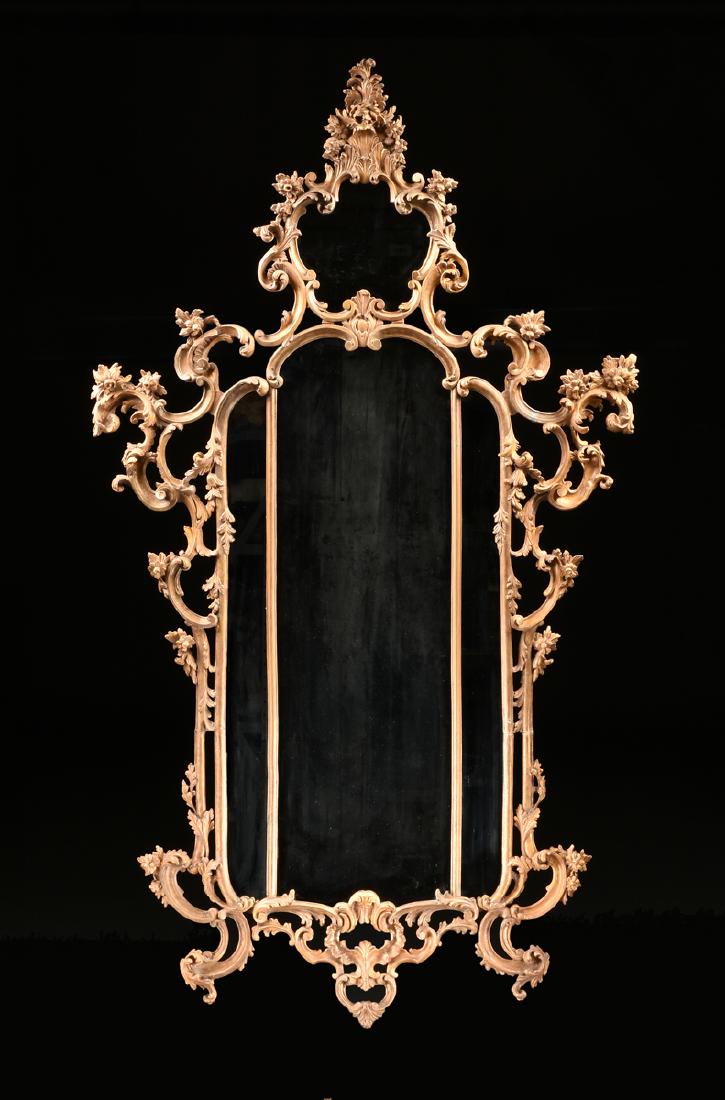after THOMAS JOHNSON (English 1714-1778) A ROCOCO: after THOMAS JOHNSON (English 1714-1778) A ROCOCO REVIVAL GILTWOOD AND COMPOSITION MIRROR, GEORGE III (1760-1820), the acanthus leaf scroll and flower bloom ornamented crest, over a pentafoil mirrored