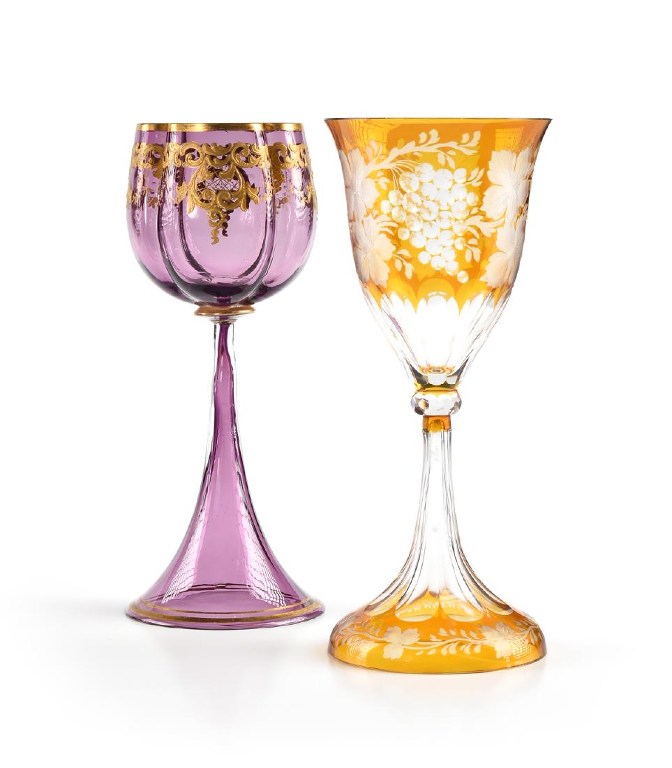 A GROUP OF TWO BOHEMIAN COLORED WINE GLASSES, CIRCA: A GROUP OF TWO BOHEMIAN COLORED WINE GLASSES, CIRCA 1900-1920, comprising a Ludwig Moser & Sohne raised gilt decorated amethyst glass stem, Karlsbad (Karlovy Vary), Bohemia, the gilt rimmed lobed quat