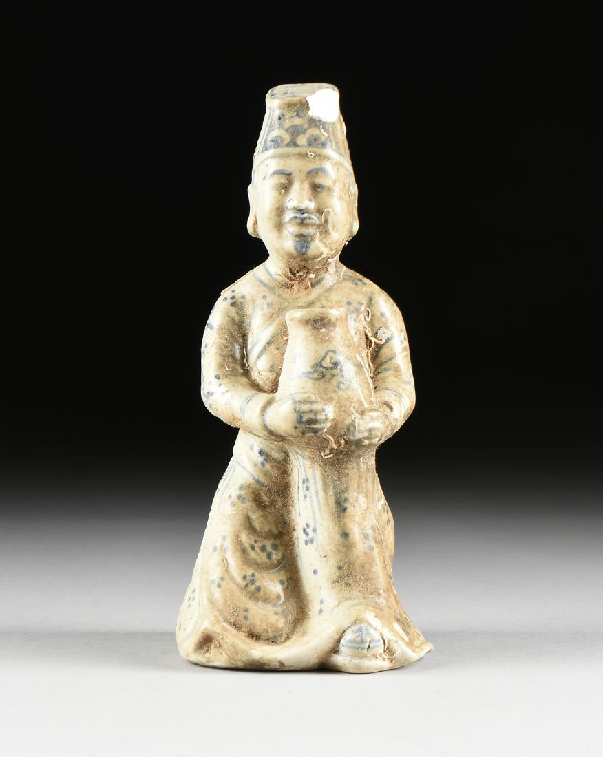 A VIETNAMESE/ANNAMESE BLUE AND WHITE PORCELAIN COURT: A VIETNAMESE/ANNAMESE BLUE AND WHITE PORCELAIN COURT OFFICIAL, LATE 15TH/16TH CENTURY STYLE, modeled in a kneeling position and wearing an angled flat top headdress centering scrolling and rectangular