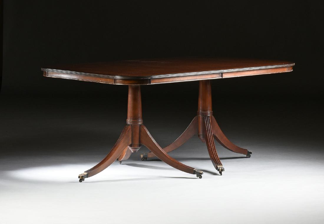A DUNCAN PHYFE (American 1768-1854) STYLE INLAID: A DUNCAN PHYFE (American 1768-1854) STYLE INLAID MAHOGANY ORMOLU PAW FOOT DOUBLE PEDESTAL DINING TABLE, MODERN, in the Neoclassical taste, the rounded corner, string inlaid, rectangular top within a r