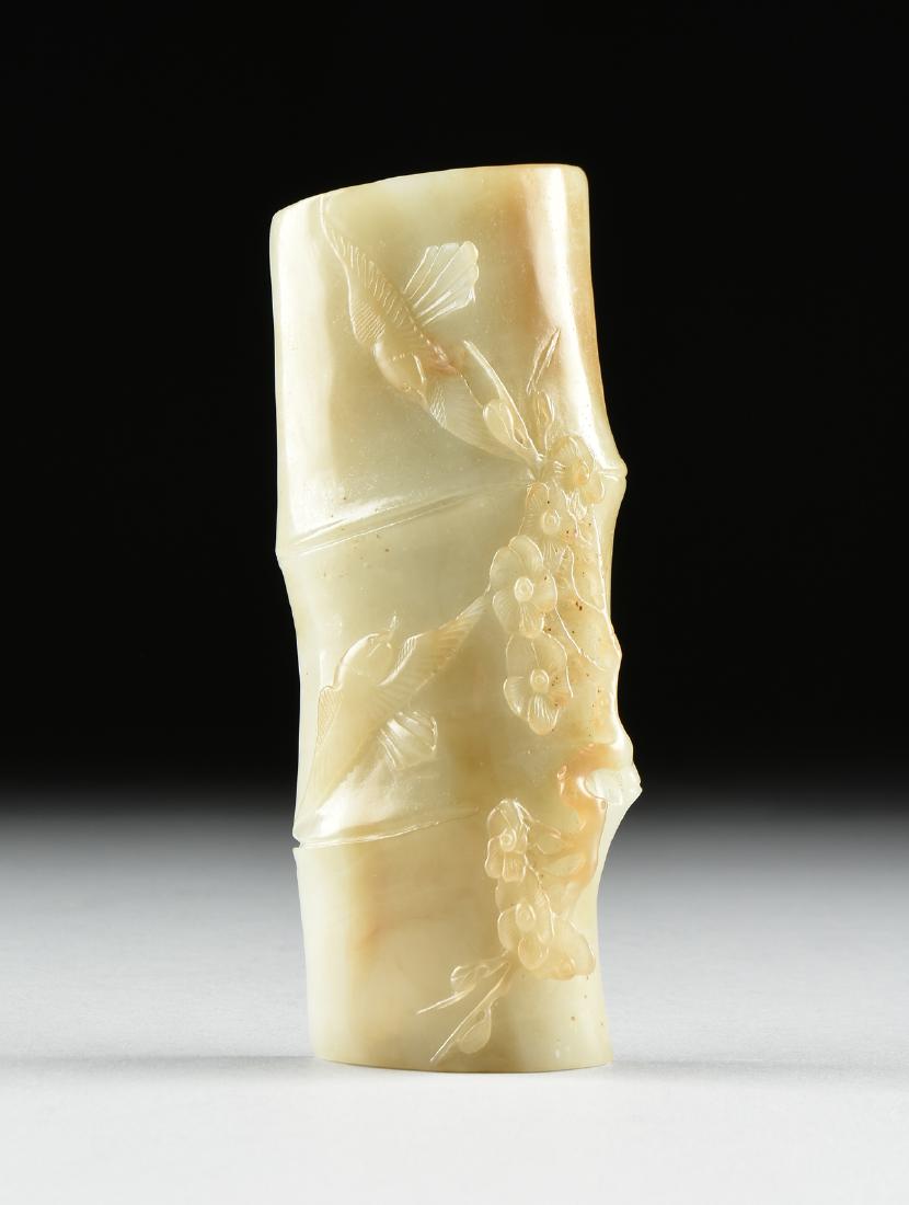 A SCHOLAR'S CELADON JADE WRIST REST, CHINESE,: A SCHOLAR'S CELADON JADE WRIST REST, CHINESE, ATTRIBUTED TO THE LATE QING DYNASTY (1644-1912), pale green with light brown inclusions, carved in the form of a bamboo stalk with relief of two sparros ,