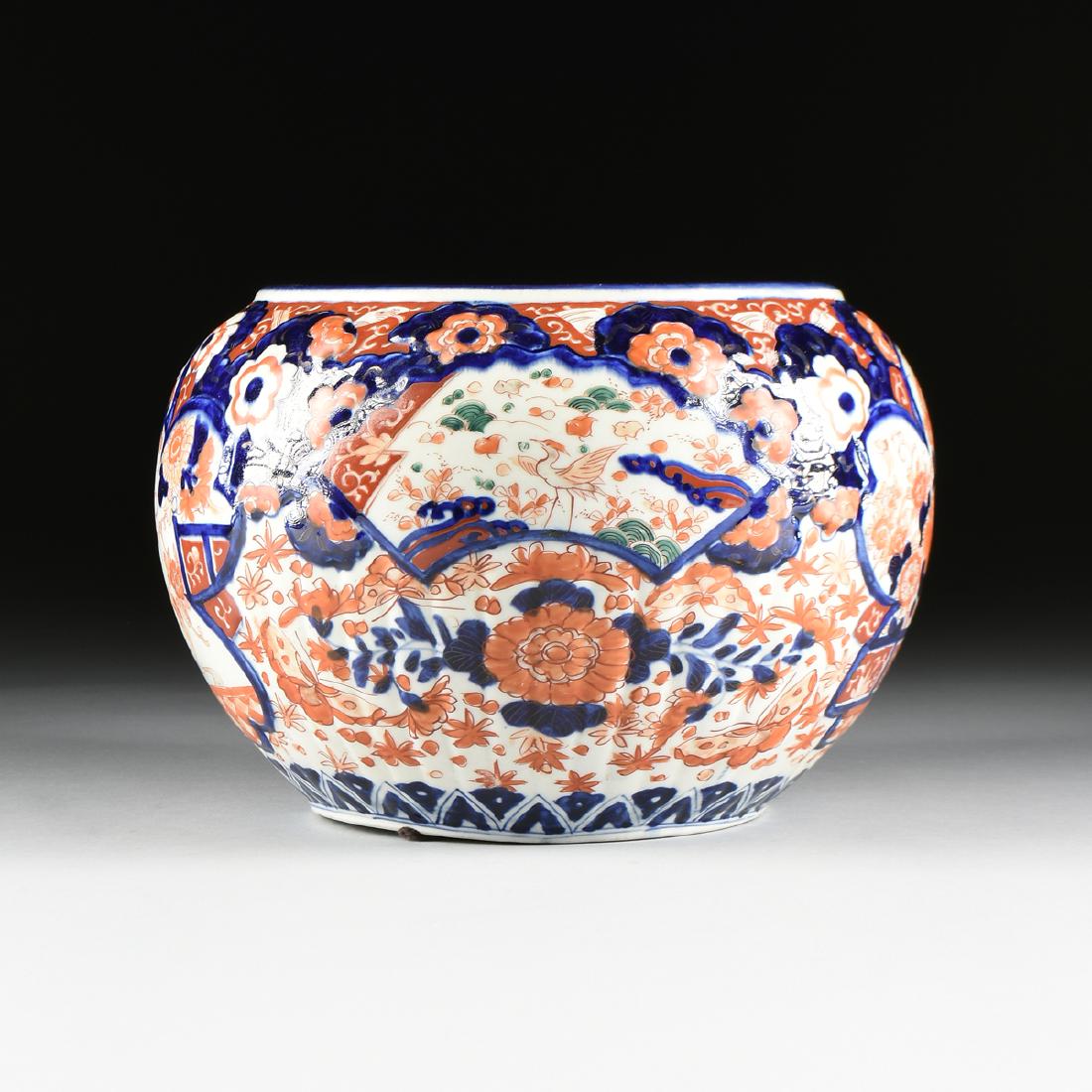 AN ENAMELED IMARI PORCELAIN CACHEPOT, JAPANESE,: AN ENAMELED IMARI PORCELAIN CACHEPOT, JAPANESE, EARLY/MID 20TH CENTURY, of globular form with floral and lobed relief, underglaze blue decoration with ironstone red enameling. Height: 9" Diameter: 9"