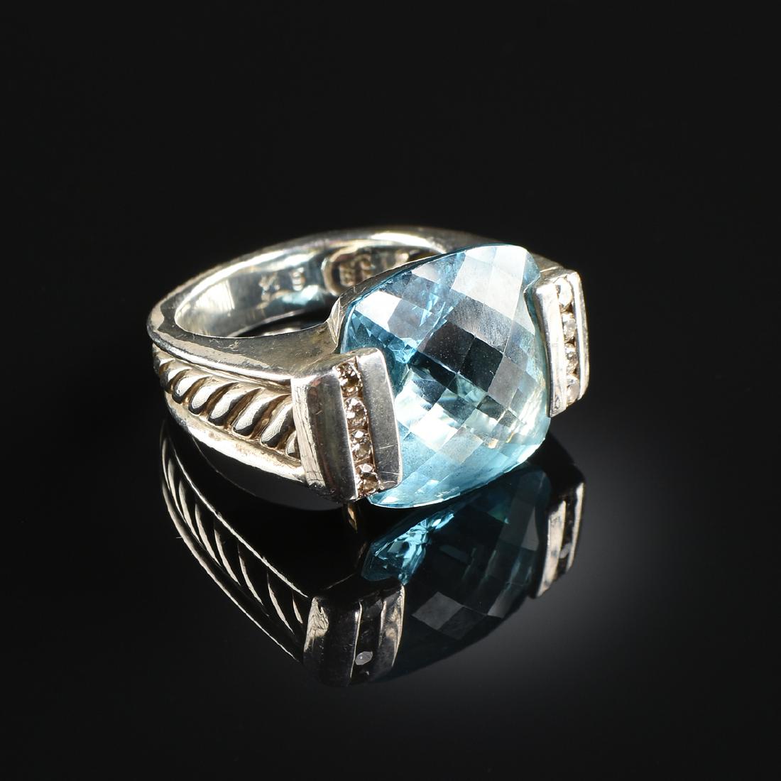 A DAVID YURMAN STERLING SILVER DIAMOND AND BLUE TOPAZ: A DAVID YURMAN STERLING SILVER DIAMOND AND BLUE TOPAZ RING, MODERN, the faceted square stone within two four round cut channel mounted prong setting, on a tapered, smooth band with central cable twist