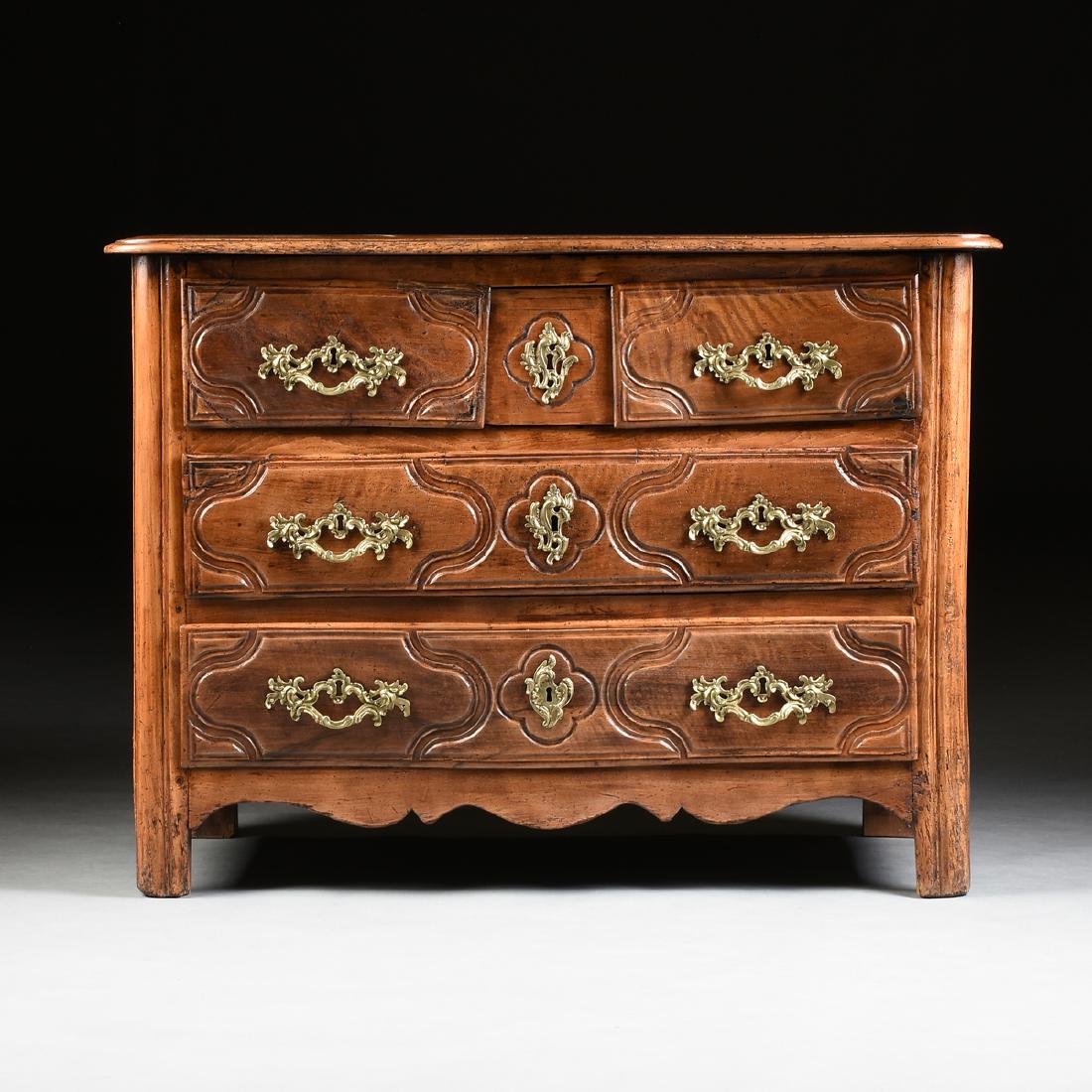 A RÉGENCE STYLE WALNUT COMMODE ÎLE DE FRANCE, FRENCH,: A RÉGENCE STYLE WALNUT COMMODE ÎLE DE FRANCE, FRENCH, MID 18TH CENTURY AND AFTER, in the Louis XVI taste, the slightly serpentine, curved corner, molded edge rectangular top, over two serpentine dra