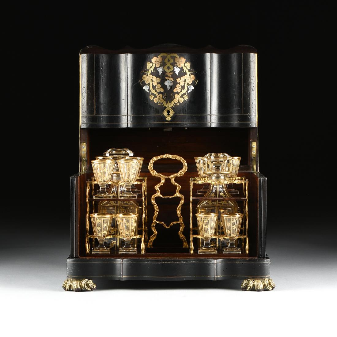 A NAPOLEON III MIXED METAL AND MOTHER-OF-PEARL INLAID: A NAPOLEON III MIXED METAL AND MOTHER-OF-PEARL INLAID EBONIZED WOOD CAVE A LIQUEURS, CIRCA 1859-1871, the shaped rectangular double hinged lid centering an inset brass urn filled with copper stemmed m