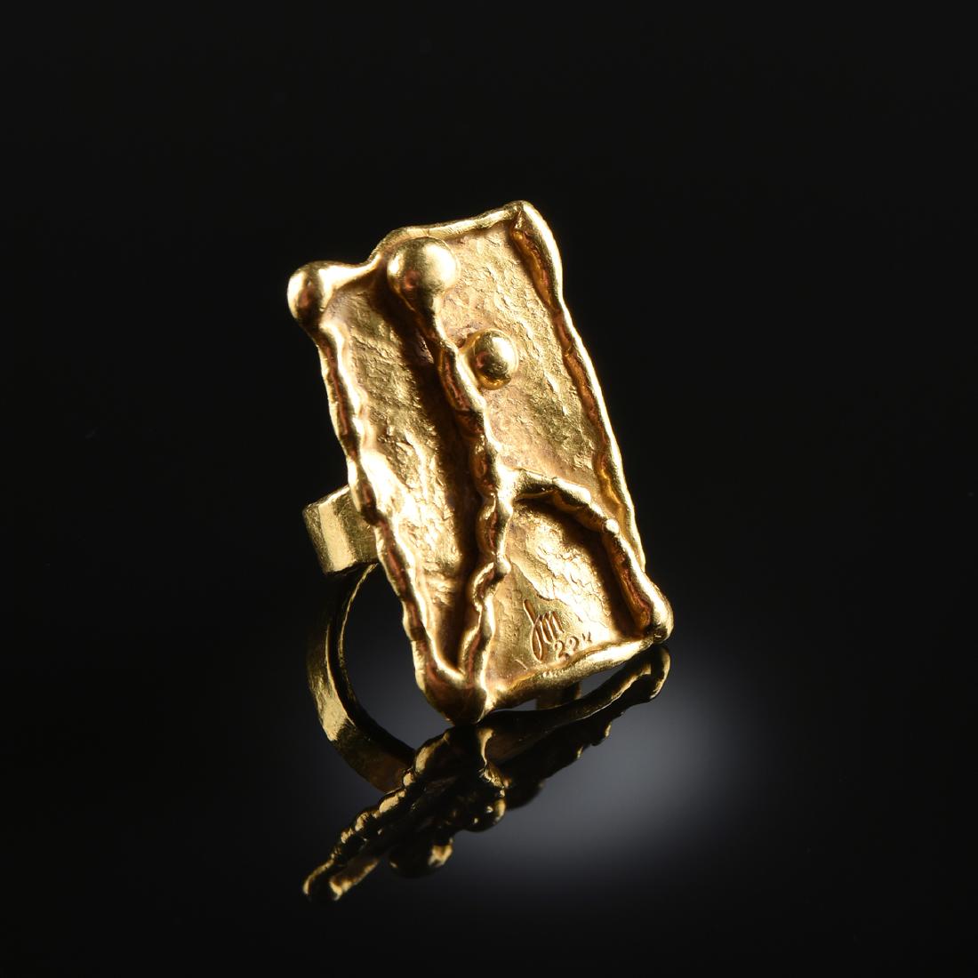 A JEAN MAHIE 22K YELLOW GOLD RING,: A JEAN MAHIE 22K YELLOW GOLD RING, stamped "JM 22K" with abstract figure in high relief design. Approximate weight: 16.3 grams. Size 6. Note: A copy of the registered bidder's government issued ID is 