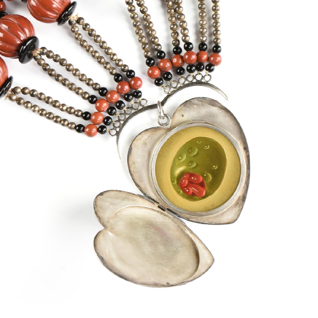DONALD ROLLER WILSON (American b. 1938) A NECKLACE,: DONALD ROLLER WILSON (American b. 1938) A NECKLACE, "Olive in a Sterling Heart Locket," lobed and faceted red jasper beads, interspersed by black onyx and silver beads, ending in a monogram engraved,