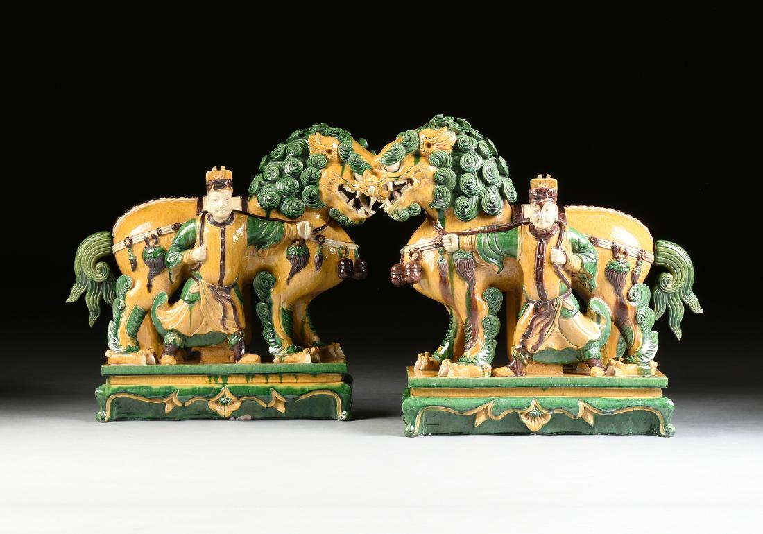 A PAIR OF CHINESE SANCAI GLAZED EARTHENWARE BUDDHISTIC: A PAIR OF CHINESE SANCAI GLAZED EARTHENWARE BUDDHISTIC LION AND ATTENDANT GROUPS, LATE 20TH CENTURY, in the Ming Dynasty style, each modeled in a standing position with scrolling mane and snarling exp