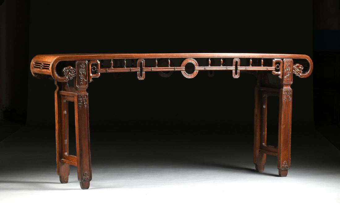 A PALATIAL CHINESE ROSEWOOD ALTAR TABLE, EARLY CHINESE: A PALATIAL CHINESE ROSEWOOD ALTAR TABLE, EARLY CHINESE REPUBLIC (1912-1949), the rectangular top with ruyi mushroom form scrolled ends, over a pierced carved skirt joined by monies and a vasiform balu