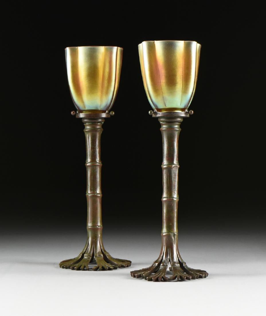 A PAIR OF TIFFANY STUDIOS PATINATED BRONZE BAMBOO: A PAIR OF TIFFANY STUDIOS PATINATED BRONZE BAMBOO CANDLESTICKS WITH STEUBEN AURENE GLASS SHADES, EARLY 20TH CENTURY, each with a removable pierced collar bobèche enclosed by three tightening screws