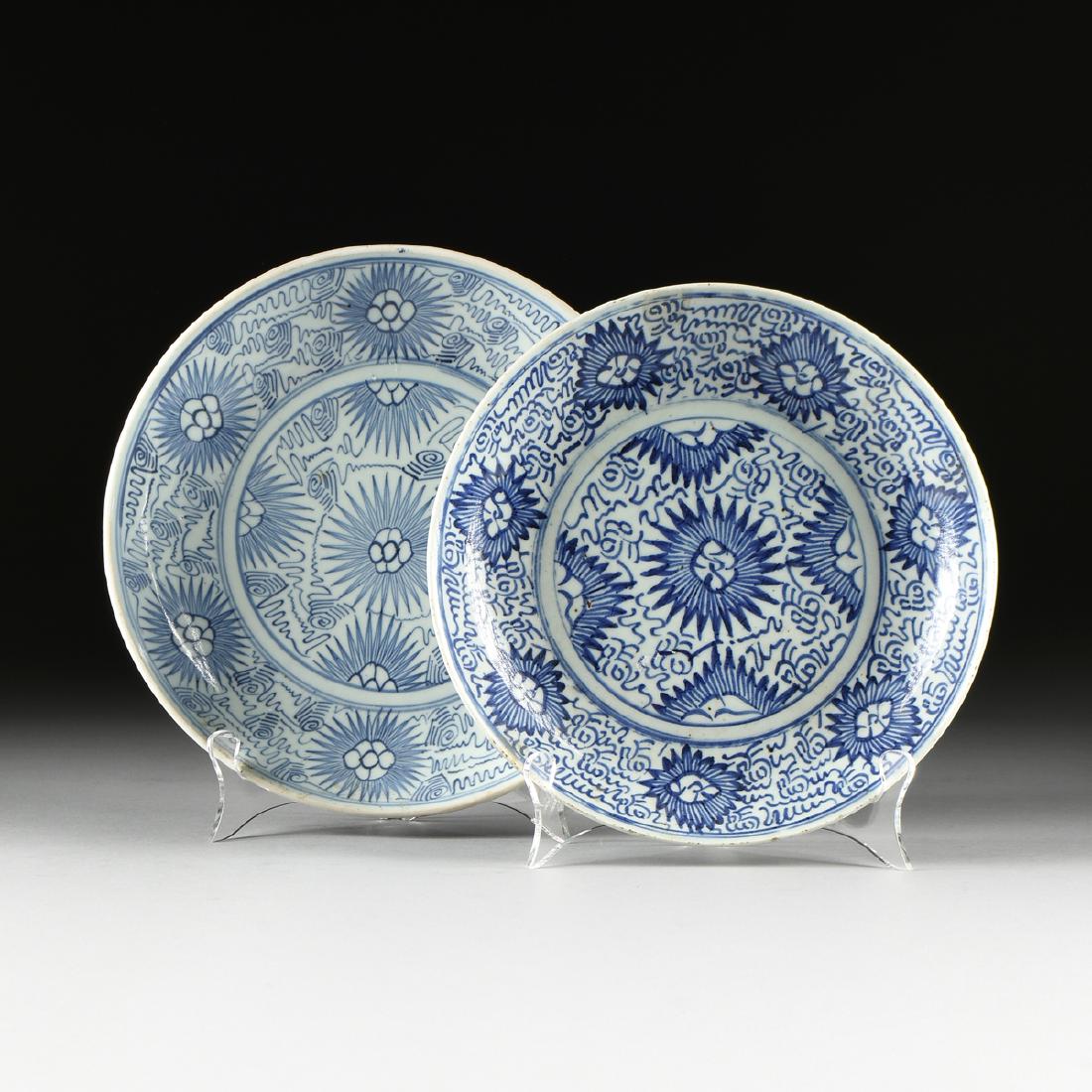 TWO CHINESE EXPORT BLUE AND WHITE GLAZED PORCELAIN: TWO CHINESE EXPORT BLUE AND WHITE GLAZED PORCELAIN PLATES, IN THE MING DYNASTY (1368-1644) TASTE, 19TH CENTURY, the welled plates with profuse provincial scrolling and sunburst flower blooms, verso th