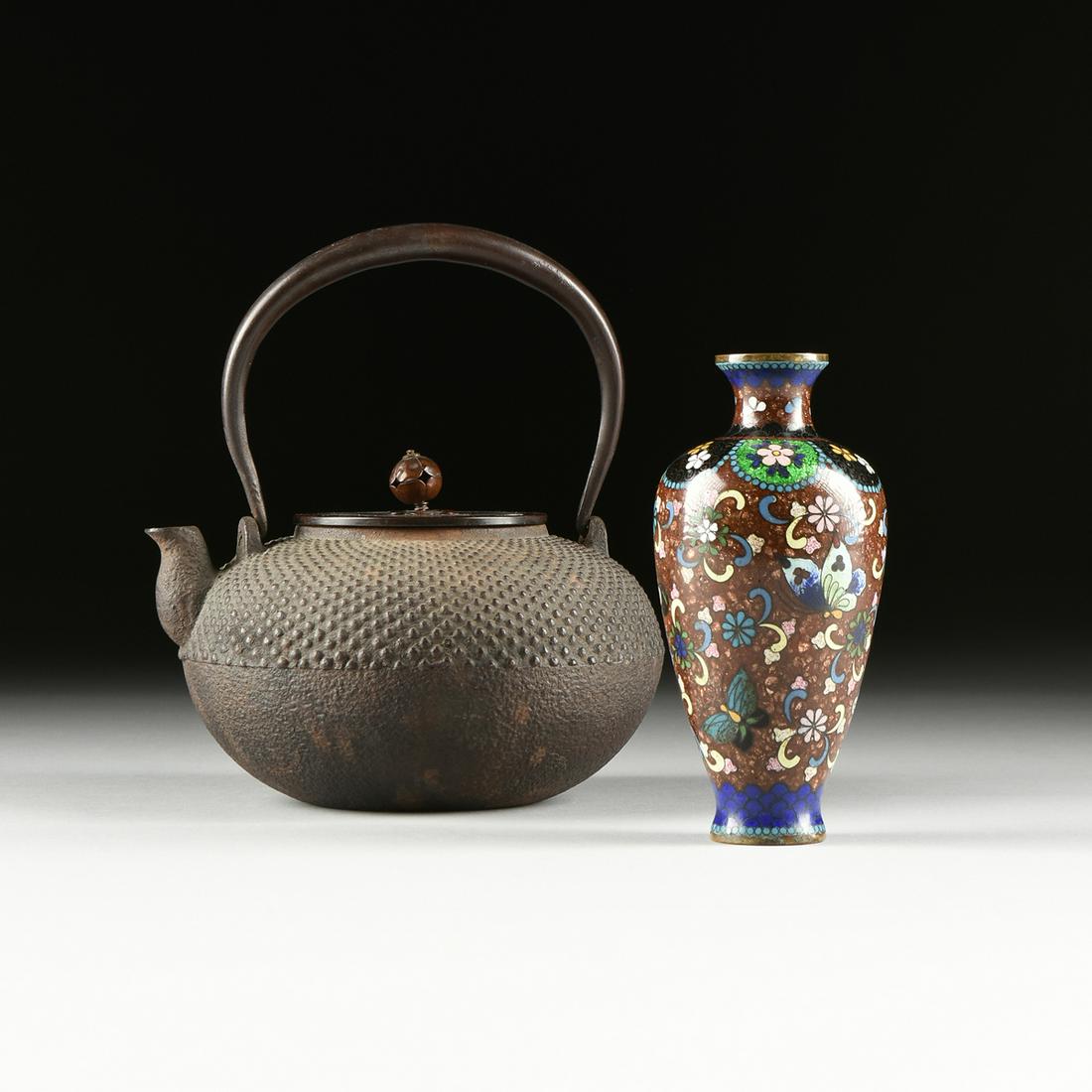 A JAPANESE IRON AND BRONZE TETSUBIN TEA KETTLE AND: A JAPANESE IRON AND BRONZE TETSUBIN TEA KETTLE AND CLOISONNÉ VASE, the teapot attributed to the Edo Period (1603-1868) with a smooth, arched hand wrought iron handle, within two "D" shape ends, c