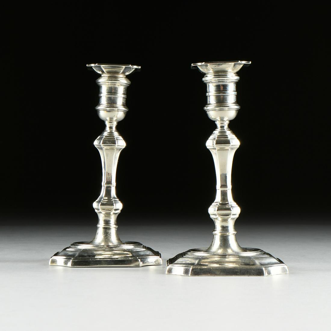 A PAIR OF CARTIER STERLING SILVER WEIGHTED: A PAIR OF CARTIER STERLING SILVER WEIGHTED CANDLESTICKS, FIRST HALF 20TH CENTURY, in the Georgian taste, the square bobêches with cavetto corners, over a banded candle cup, raised on a 