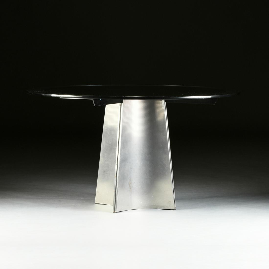 A MAISON JANSEN GLASS AND BRUSHED STEEL BREAKFAST: A MAISON JANSEN GLASS AND BRUSHED STEEL BREAKFAST TABLE, DESIGNED BY LUIGI SACCARDO, FRENCH, 1970s, the thick circular clear glass top enclosing an underside with conforming black enameled panel, rais