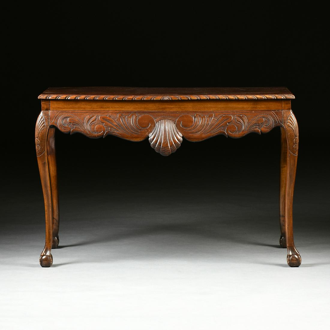AN AMERICAN CHIPPENDALE CARVED MAHOGANY CONSOLE TABLE,: AN AMERICAN CHIPPENDALE CARVED MAHOGANY CONSOLE TABLE, LATE 18TH CENTURY, the rectangular top enclosed by gadrooned trim above a flat frieze and undulating bombé skirt, robustly carved with shall