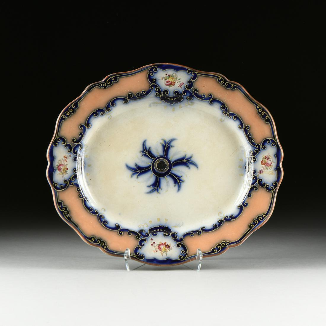 A CONTINENTAL IRONSTONE ROCOCO REVIVAL PLATTER, EARLY: A CONTINENTAL IRONSTONE ROCOCO REVIVAL PLATTER, EARLY 20TH CENTURY, of serpentine ovoid form with underglaze cobalt blue and peachy orange reserves interspersed by hand painted floral bouque
