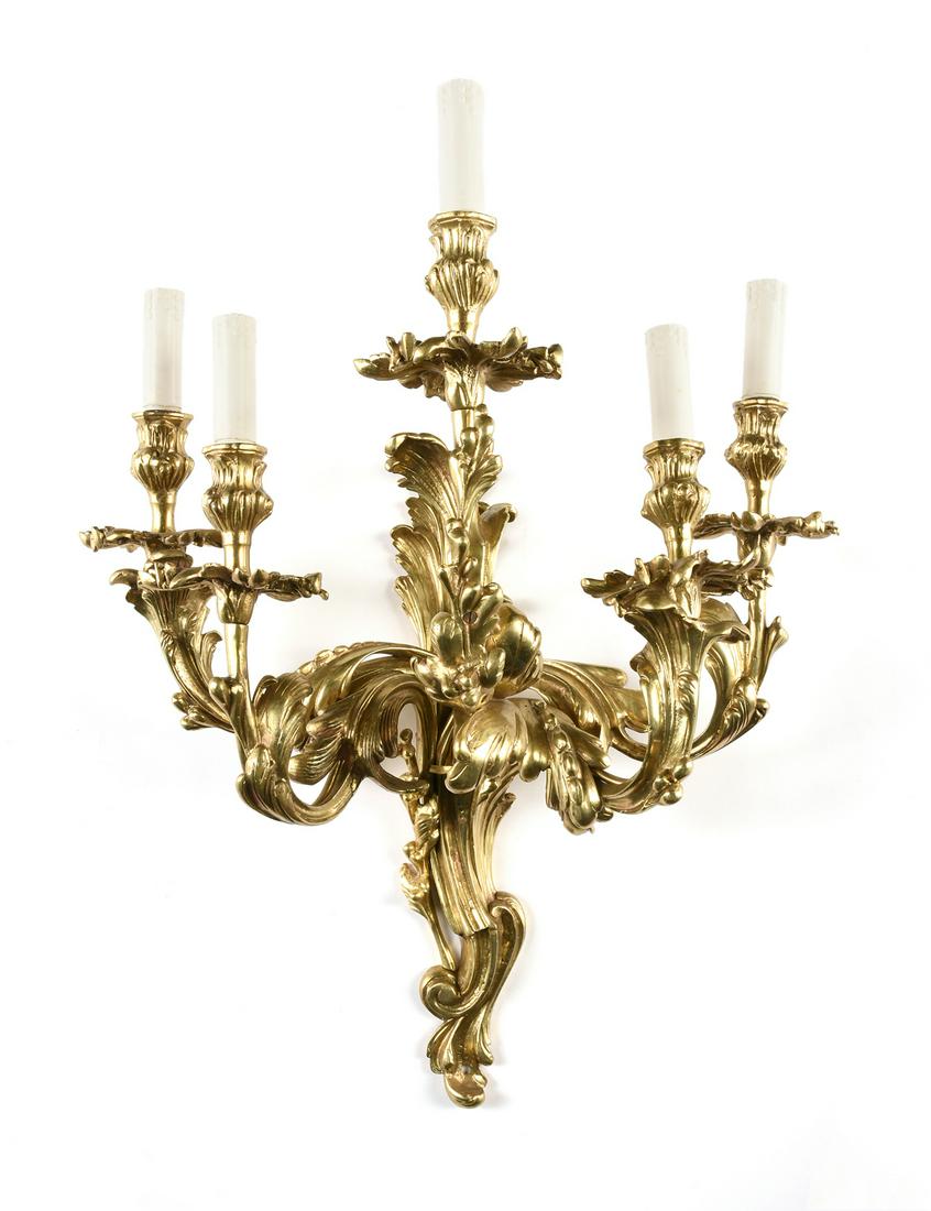 A LOUIS XV STYLE GILT BRONZE FIVE LIGHT WALL SCONCE,: A LOUIS XV STYLE GILT BRONZE FIVE LIGHT WALL SCONCE, LATE 20TH CENTURY, with an undulating scrolling acanthus cast backplate issuing similarly modeled swirling branches, ending in spinning leaf bob