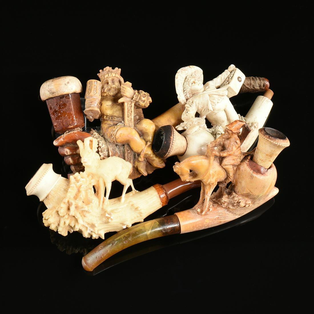 A GROUP OF FOUR MEERSCHAUM PIPES, LATE 19TH/EARLY 20TH: A GROUP OF FOUR MEERSCHAUM PIPES, LATE 19TH/EARLY 20TH CENTURY, carved in the form of a boy flower seller with hat and glass inlay, a man on horseback, a king with chalice and sword, and a ram, larges